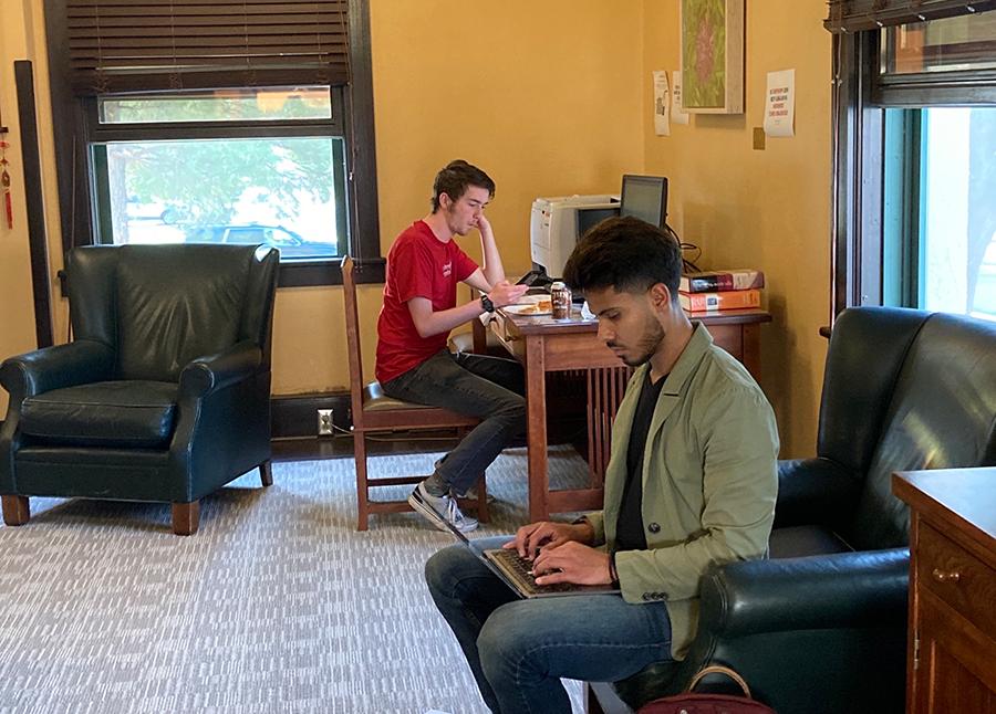  两个男人坐在办公室里摆弄电脑
